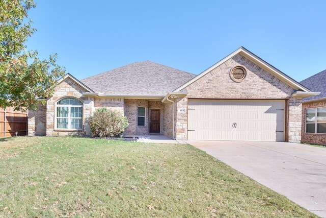 view of front of property with a front yard and a garage