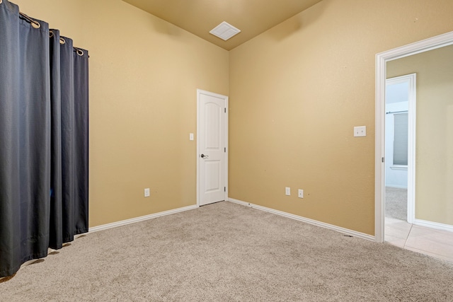 carpeted spare room with vaulted ceiling