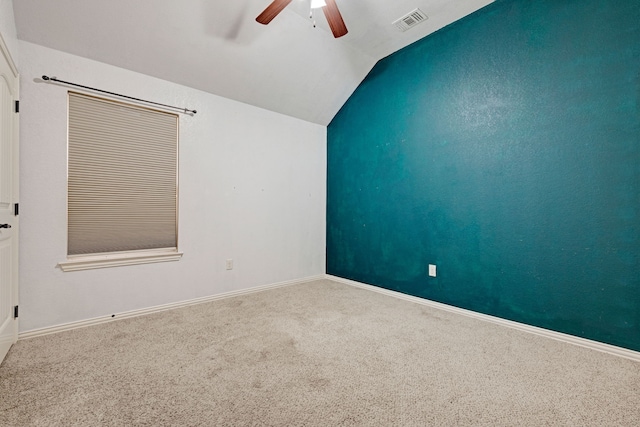 carpeted spare room featuring ceiling fan and lofted ceiling