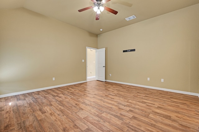 spare room featuring light wood-type flooring, vaulted ceiling, and ceiling fan