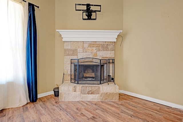 interior details featuring a stone fireplace and hardwood / wood-style flooring