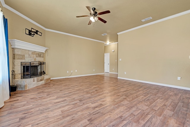 unfurnished living room with ceiling fan, a stone fireplace, light wood-type flooring, and ornamental molding