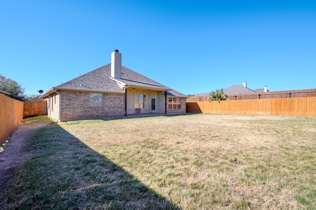 rear view of house featuring a lawn