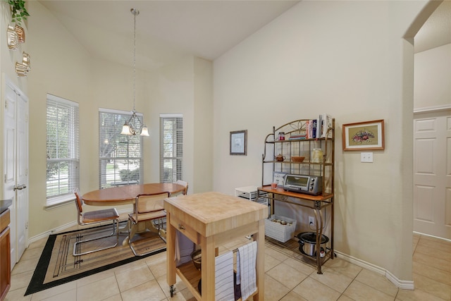 home office featuring a chandelier, light tile patterned floors, and high vaulted ceiling