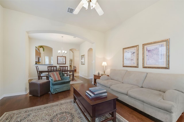 living room featuring dark hardwood / wood-style floors and ceiling fan with notable chandelier