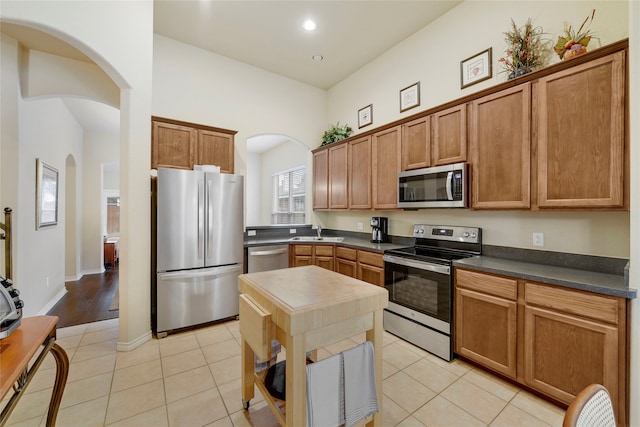 kitchen featuring stainless steel appliances, light tile patterned flooring, and sink