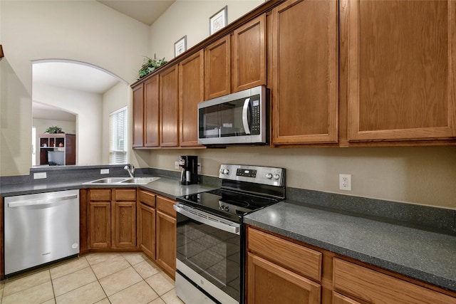 kitchen featuring light tile patterned flooring, sink, and stainless steel appliances