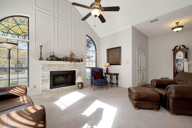 living room with a fireplace, light colored carpet, high vaulted ceiling, and ceiling fan