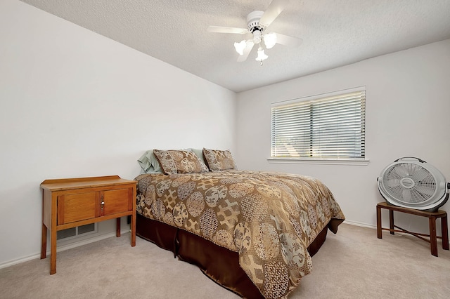 carpeted bedroom featuring a textured ceiling and ceiling fan