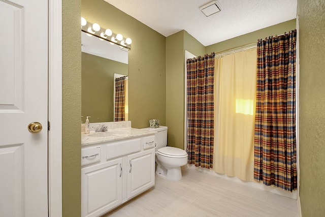 bathroom with vanity, a textured ceiling, and toilet