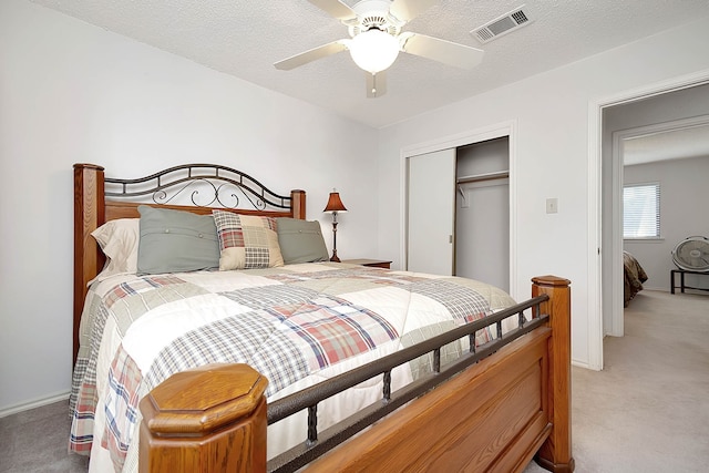 carpeted bedroom with ceiling fan and a closet