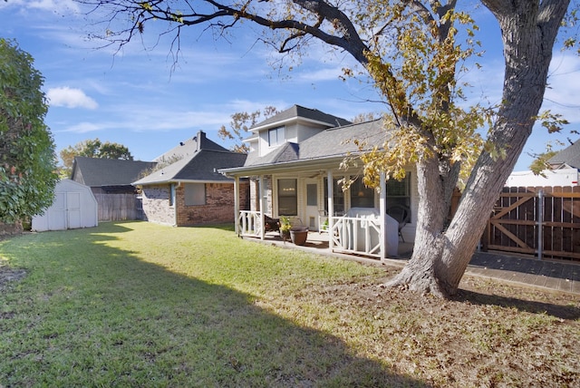 back of house featuring a lawn, a storage shed, and a patio