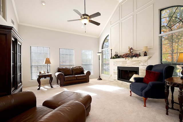 living room with light colored carpet, ceiling fan, crown molding, a tile fireplace, and high vaulted ceiling