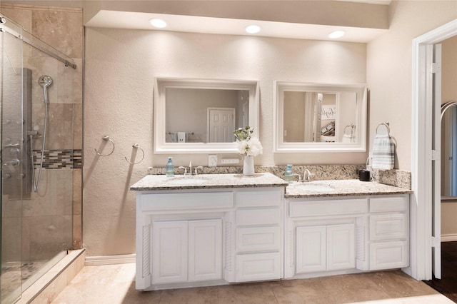 bathroom featuring tile patterned flooring, vanity, and a shower with shower door