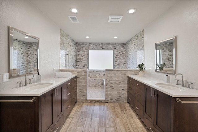 bathroom featuring plenty of natural light, vanity, and tile walls