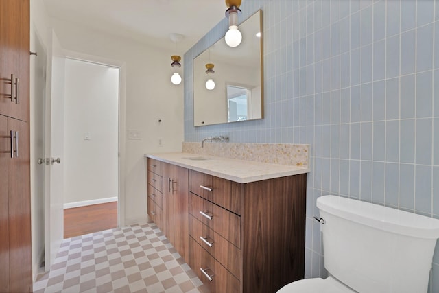 bathroom featuring hardwood / wood-style flooring, vanity, toilet, and tile walls