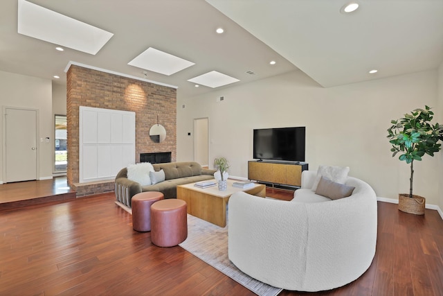 living room with a large fireplace and hardwood / wood-style flooring