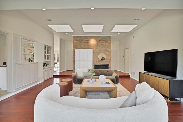 living room featuring dark hardwood / wood-style flooring and a large fireplace