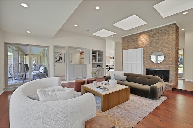 living room with hardwood / wood-style flooring, a fireplace, and a skylight