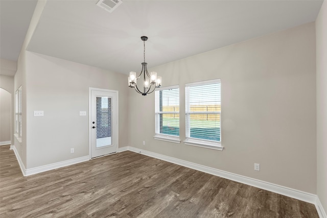 empty room featuring hardwood / wood-style floors and an inviting chandelier