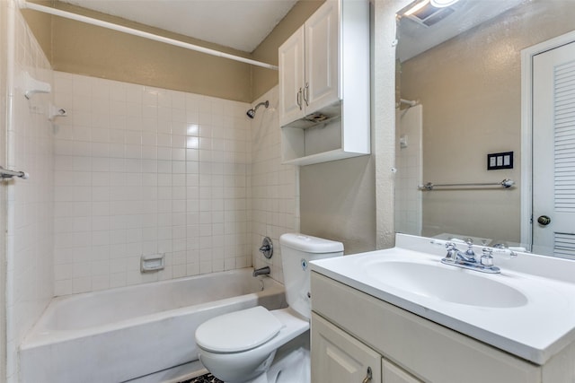 full bathroom with tiled shower / bath, vanity, and toilet