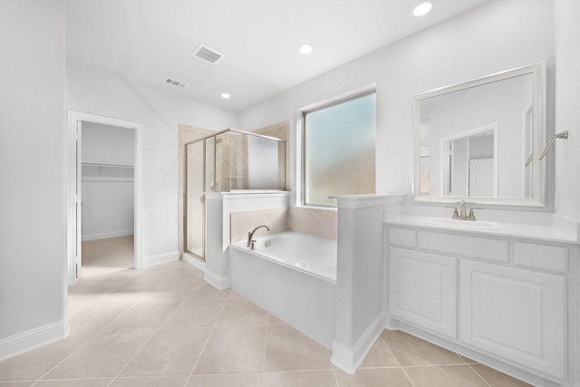 bathroom featuring tile patterned floors, vanity, and shower with separate bathtub