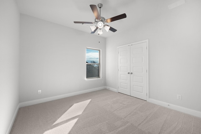 unfurnished bedroom with ceiling fan, a closet, and light carpet