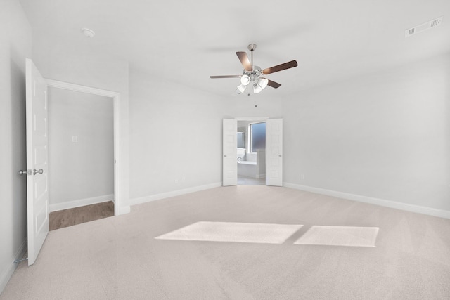 carpeted spare room with ceiling fan