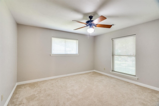 carpeted spare room featuring ceiling fan