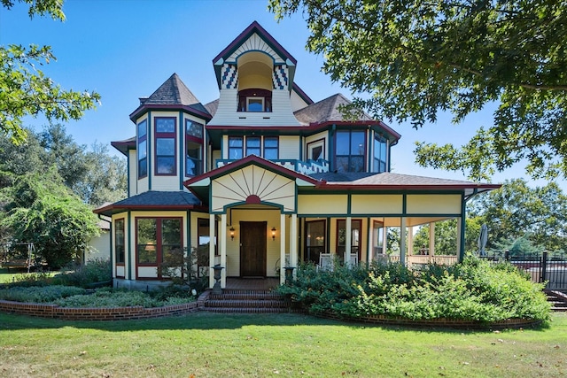 victorian home featuring covered porch and a front yard