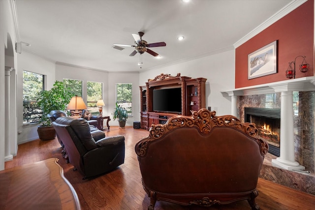 living room with crown molding, a fireplace, ceiling fan, and wood-type flooring