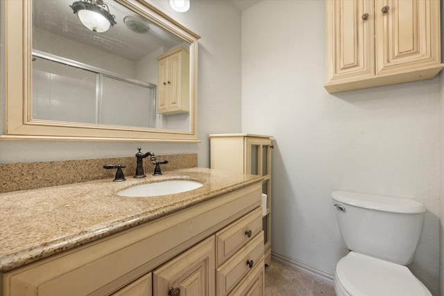 bathroom featuring vanity, an enclosed shower, and toilet