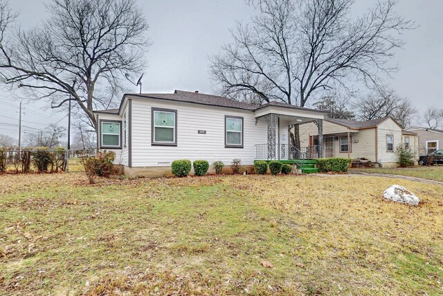 view of side of home with covered porch and a yard