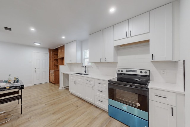 kitchen with sink, white cabinetry, light wood-type flooring, stainless steel electric stove, and decorative backsplash