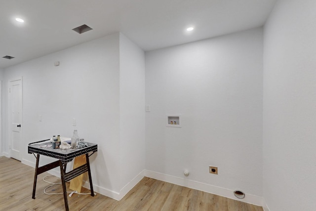 washroom featuring electric dryer hookup, hookup for a washing machine, and light hardwood / wood-style flooring