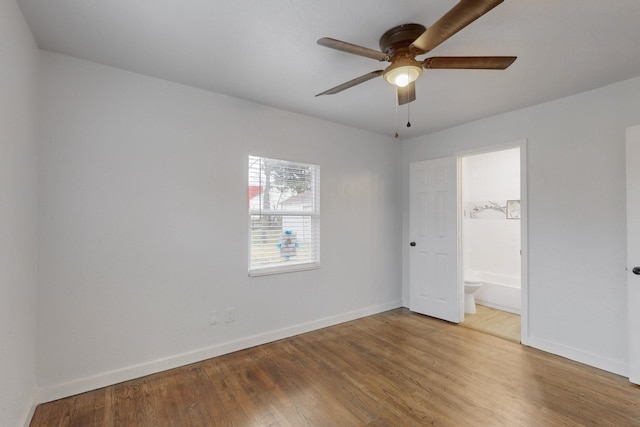 unfurnished bedroom featuring ceiling fan, hardwood / wood-style floors, and ensuite bath