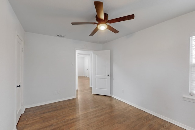 empty room featuring dark wood-type flooring and ceiling fan