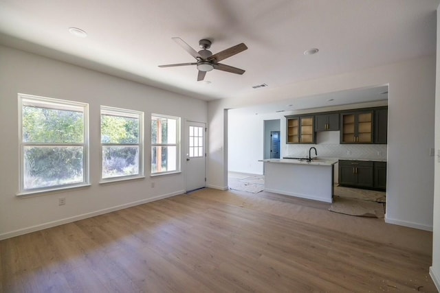 unfurnished living room featuring ceiling fan and light wood-type flooring