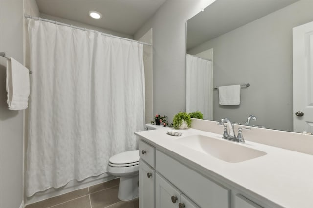 bathroom with toilet, vanity, and tile patterned floors