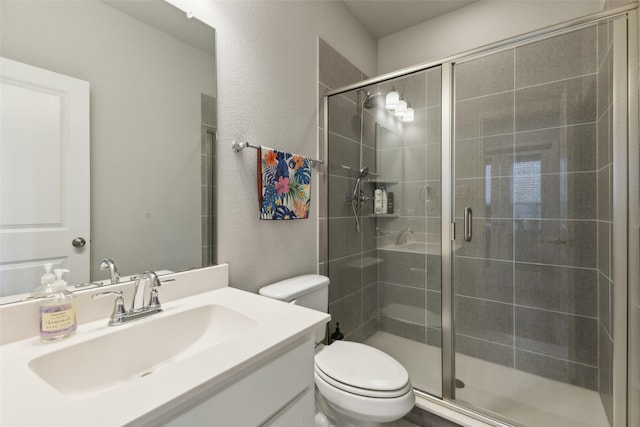 bathroom featuring vanity, walk in shower, and toilet