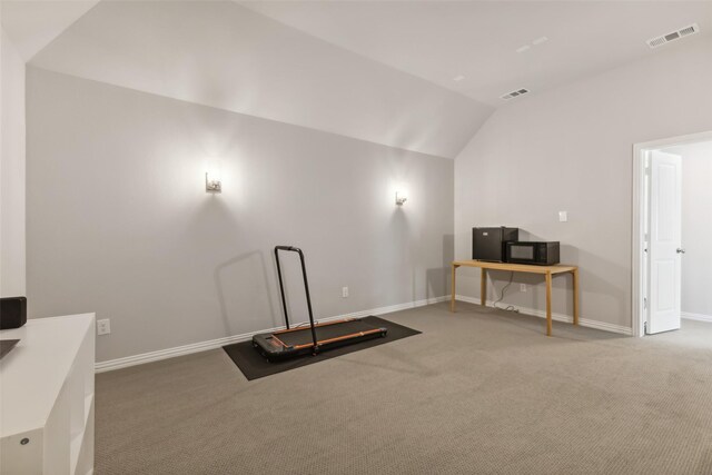 exercise room with carpet floors and vaulted ceiling