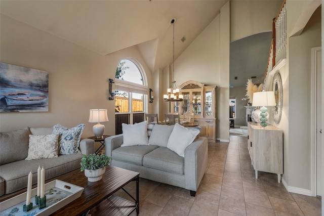 tiled living room featuring high vaulted ceiling and a notable chandelier