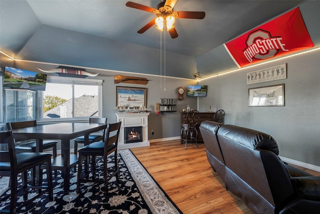 dining room with wood-type flooring, vaulted ceiling, and ceiling fan