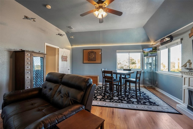 living room with light wood-type flooring, ceiling fan, and lofted ceiling