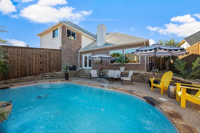 view of pool with a patio area, french doors, an outdoor hangout area, and pool water feature