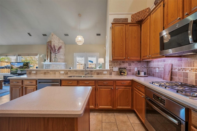 kitchen featuring a center island, appliances with stainless steel finishes, tasteful backsplash, sink, and decorative light fixtures