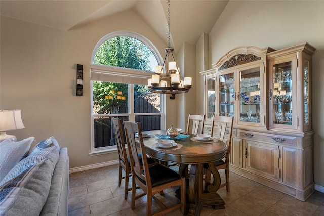 tiled dining space with an inviting chandelier and vaulted ceiling