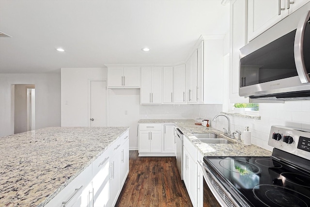 kitchen featuring sink, stainless steel appliances, light stone counters, dark hardwood / wood-style flooring, and white cabinets