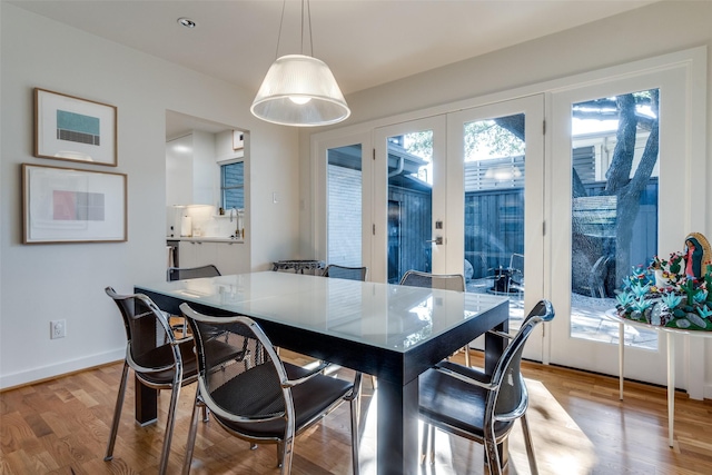 dining space with french doors and light hardwood / wood-style floors