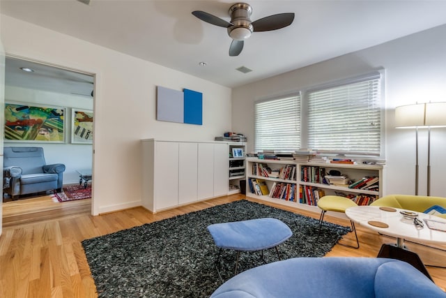 sitting room with light hardwood / wood-style floors and ceiling fan